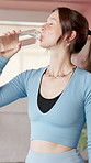 Woman, drinking water and break at gym with fitness, hydration and wellness routine at class. Girl, bottle and aqua for digestion, electrolytes or rest for exercise, training and pilates at club