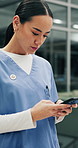Woman, doctor and phone for texting in hospital lobby, break or web chat in medical career. Person, surgeon and healthcare professional on smartphone, mobile app or contact on social media at clinic