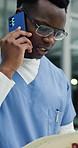 Black man, surgeon and phone call at hospital with report, emergency services and contact in lobby. African person, medical professional and smartphone with folder, paperwork and discussion at clinic