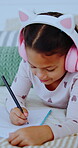 Child, headphones and writing notes in bedroom for education, listening to music and homework. Smile, kid and notebook for streaming podcast, studying and assessment for learning revision at house