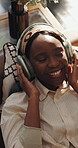 Dance, headphones and relax with black woman on sofa for streaming, song playlist and smile. Music subscription, happiness and entertainment with above of person in living room of home for radio