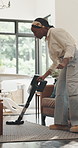 Vacuum, carpet and black woman in home for cleaning, maintenance and housekeeping chores. Happy, apartment and person in living room with machine for floor hygiene, dust prevention and housework