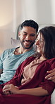 Couple, watching movie or film in bedroom with smile for comedy, connection or bonding together. Married people, relax or laugh in home with funny show, social media entertainment or streaming series