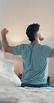 Back, stretching and wake up with man in bedroom of home for start of day or morning on weekend. Awake, relaxed and rested with person on bed in apartment for cozy comfort, me time or recovery