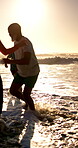 Senior man, friends and play at beach, waves and kick water with smile, games and bonding at sunset. Elderly people, group and excited with splash, running or ocean with laugh outdoor in retirement