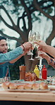 Hands, people and cheers with champagne outdoor for lunch, celebration and thanksgiving. Smile, friends and toast alcohol with food for reunion event, social gathering and bonding together at house