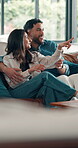 Happy couple, watching tv and hug on couch together,  pointing and laughing at funny movie scene. Bonding, streaming film or woman with man chill in home, subscription platform and support on weekend