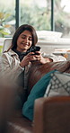 Happy, home and woman on sofa, smartphone and message to contact, internet and texting. Apartment, smile or person on couch, cellphone and digital app for social media, connection and relax in lounge