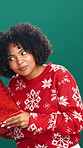 Christmas, gift and face of woman with guess for holiday, tradition and festive season in studio. Happy, December and portrait of person with present for celebration, xmas and box on green background
