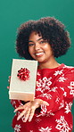 Present, christmas and face of woman in studio for festive celebration, holiday or event. Happy, giveaway and portrait of excited female person with xmas gift box for tradition by green background.