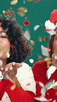 Face, women and confetti on Christmas in studio for celebration, holiday spirit and fun tradition. Portrait, people and blow glitter for festive, xmas party and sparkle decoration on green background