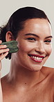Face, happy woman and skincare in studio with gua sha for lymphatic drainage, beauty or dermatology. Smile, person and facial tool for blood circulation, healthy skin or wellness on white background.