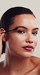 Beauty, face and mascara with woman in studio for cosmetics, facial or makeover routine. Apply, freckles and makeup with confident model on white background for aesthetic, change or transformation