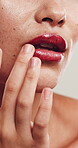 Makeup, touch and woman with lip gloss in studio, beauty aesthetic and mouth color for shine finish. Cosmetology, self care and person with glossy balm for hydration glow, wellness and closeup.