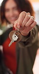 Woman, hand and moving in home with key for property investment, real estate goals and new beginning. Person, celebration and holding keyring in dream apartment with pride, mortgage loan and success.