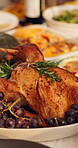 Thanksgiving, roast and turkey on table in dining room for festive holiday, feast decoration and meal. Culture, season and dinner with chicken and spread in home for event, dishes and food setup