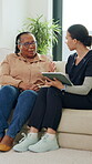 Tablet, consulting and old woman with nurse on sofa for healthcare, retirement or support. Online patient records, treatment plan and advice with people in nursing home for medical caregiver