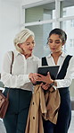 Business women, walking and assistant with tablet, schedule and giving coffee in company. Mature CEO, secretary and happy team with technology, arrival and start discussion with document for advice