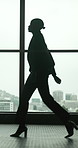 Business woman, silhouette and walking with window in confidence for corporate journey or travel. Female person, employee or traveler with bag in city building for company trip or career opportunity
