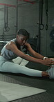 Fitness, woman and leg stretching at gym to start workout, muscle coordination or flexibility. Health club, black person or warm up on floor for exercise preparation, getting ready or enhance posture