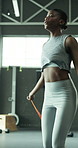 Woman, exercise and skipping in gym for fitness, improve coordination or cardio training. African person, rope or jumping in health club for intense workout, muscle growth or endurance development