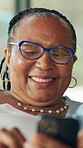 Cellphone, happy and senior black woman in home with networking, chatting or social media on app. Technology, relax and African elderly female person in retirement with blog on phone in living room.