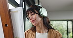 Painting, canvas and woman with headphones in home with inspiration for drawing, artwork and design. Happy, house and person with easel, art project and paintbrush for creative hobby, music and audio