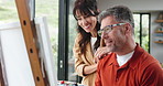 Happy, painting and couple with canvas for hobby, creative project and bonding with artwork in home. Marriage, love and man talking to woman for drawing, artistic creation and picture with easel