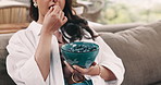 Hands, eating blueberry and sofa in home with diet, organic produce or streaming movies in living room. Woman, relax and watching tv with fruit for benefits, nutrition and film on couch at apartment