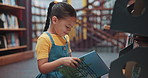 Reading, library and child on floor with books for learning, education and language development. Happy, childhood and girl with literature, storybook and novel for knowledge, research and information
