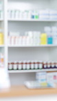 Pharmacy, blurry and tablets in drug store, medicine and supplements with shelves. Empty, stock and inventory with wellness, healthcare and service with pharmaceuticals, retail and medical products