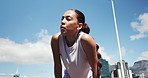 Low angle, tired and woman in city, training and exhausted with workout, breathing and wellness. Outdoor, athlete and healthy person with fitness, fatigue or rest with break, challenge and endurance