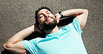 Rest, fitness and above of man on road for recovery after workout, running and training outdoor. Tired, sports and person relax, breath and laying on street for wellness, health and exercise break