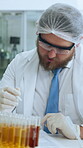 Test tubes, scientist and writing report in lab for sample study, DNA results or medical experiment. Science innovation, safety and man with notes for biomedical research and color coding body fluid