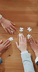 Hands, business people and team with puzzle game in office for synergy, collaboration and solution for project. Group, above and employees for problem solving, jigsaw or link for strategy at agency