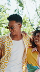 Laughing, friends and walking with hug at park for bonding together, social gathering and fresh air. Low angle, flare and happy people with stroll in nature for weekend break, holiday reunion or care