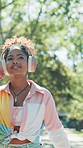 Thinking, girl and walking with headphones at park for music playlist, exploring nature and fresh air. Reflection, happy person and stroll with smartphone for streaming podcast and weekend adventure