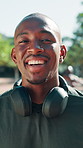 Face, headphones and black man with fitness, outdoor and exercise with confidence. African person, happiness and runner with pride, wellness and workout with balance, radio and training with practice