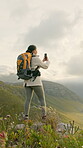 Woman, hiking photography of mountain view with phone for social media post, travel or adventure. Person, trekking on hill with tech for picture, online nature blog or mobile app to document memories