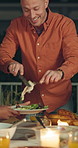 Happy man, night and serving with turkey for thanksgiving meal or gathering at dinner table. Male person, dishing and group of friends in late evening with plate, chicken or candle light for feast