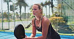 Woman, playing and ready with padel tennis for ball, smash or sport training on outdoor court. Active, female person or player swinging with bat or determination for game, match or practice on turf