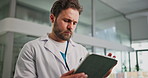 Tablet, doctor and man in hospital for medical review, report or patient history. Technology, reading and serious healthcare worker with telehealth, insurance records and check schedule in clinic