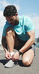 Athlete, man and tying shoes on road for getting ready, fitness preparation and exercise. Male person, lace and footwear for sports training, runner safety and practice for endurance challenge