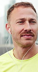 Earphones, sports and man in city with music for running, workout or training with challenge. Audio tech, thinking and male athlete with listening to playlist, album or podcast for cardio exercise.