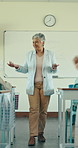 Woman, education, and teacher in classroom, talking and knowledge with lesson. Mature person, learning and happy employee in school, discussion and attention with support, teaching and academic test