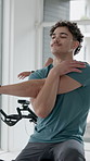 Stretching, exercise bike and man in gym, training and wellness with fitness, endurance and warm up. People, equipment or cycling in health center, joint mobility and challenge with workout or cardio