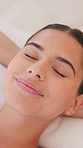 Woman, face and smile on spa bed for massage, rest and rehabilitation with eyes closed at resort. Person, sleep and happy for holiday, wellness or break with dream, luxury and service at lodge