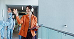 Happy woman, greeting and listening with headphones to music for work energy in office hallway. Creative, female person or group with high five for positive attitude or company vibe in workplace