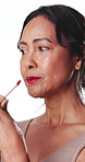 Woman, red lipstick application or makeup in studio with smile, beauty aesthetic or glowing skin. Happy, mature person or bold lip gloss for shine, confidence or vibrant cosmetic on white background.