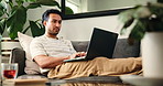 Laptop, relax and typing with man on sofa in living room of home for college or university assignment. Break, computer and report with person in apartment for education, learning or online study